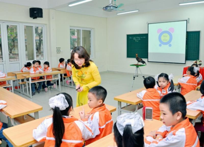 Cô giáo đang giảng bài về môi trường cho học sinh trong lớp học, nhấn mạnh tầm quan trọng của việc học tập