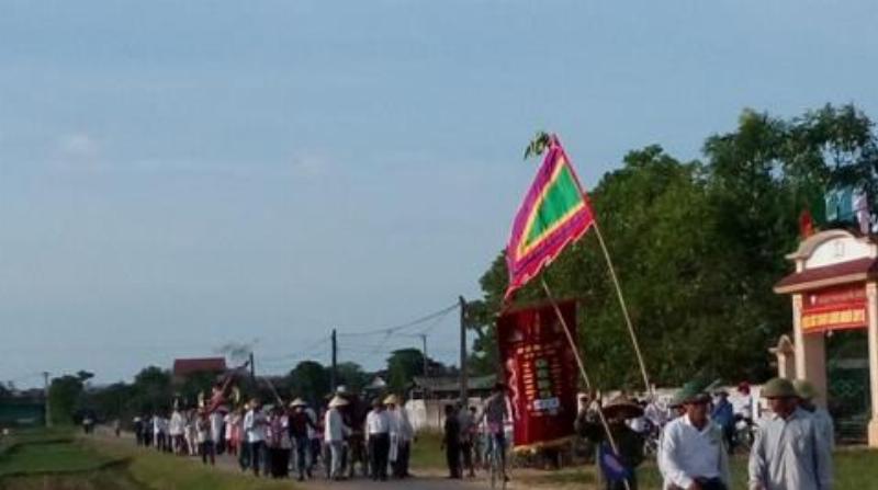 Hình ảnh một người phụ nữ quỳ trước ban thờ trong đền, tay chắp hoặc cầm sớ khấn, thể hiện sự trang nghiêm trong nghi thức.