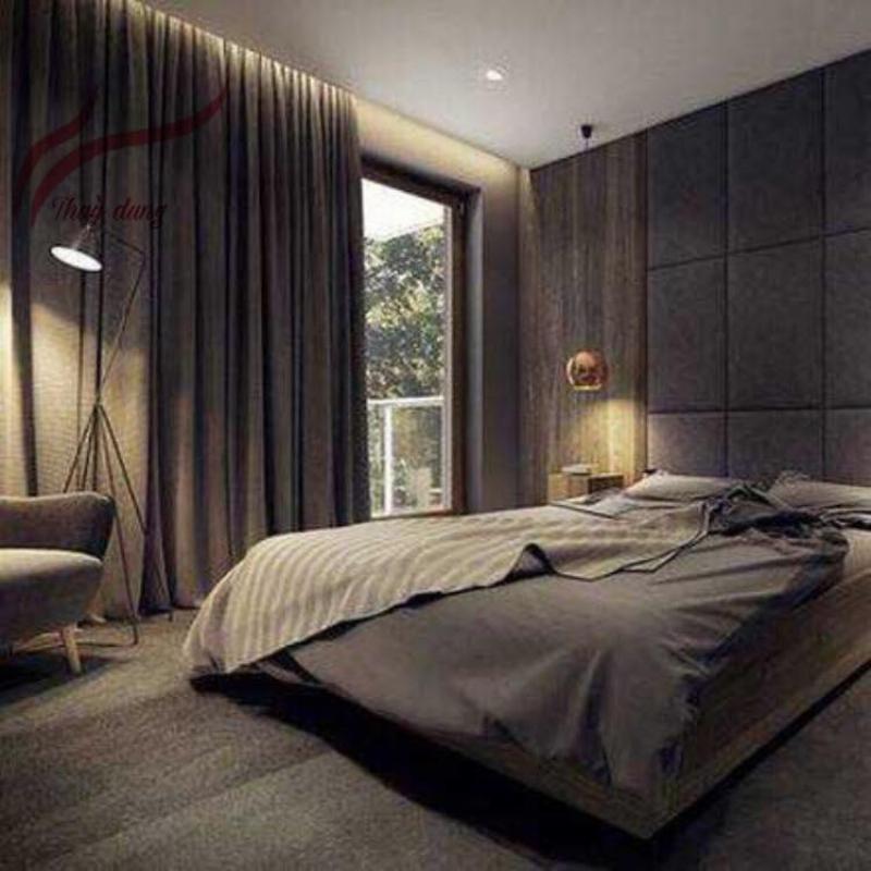 Một căn phòng khách được trang trí theo phong thủy mệnh Mộc, với gam màu xanh lá cây chủ đạo trên tường và rèm cửa, kết hợp với các chi tiết màu đen của đồ nội thất và nhiều cây xanh tươi mát. Ánh sáng tự nhiên chiếu vào, tạo cảm giác hài hòa và bình yên.