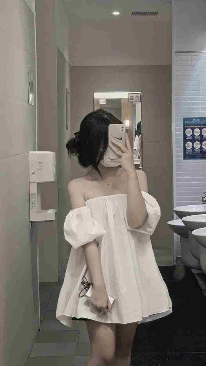 Cô gái ngồi trầm tư, che mặt bằng cuốn sách giữa không gian tĩnh lặng