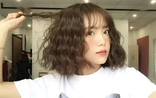 Cô gái tự tin với kiểu tóc ngắn uốn bồng bềnh, tạo sự tươi trẻ và đầy sức sống