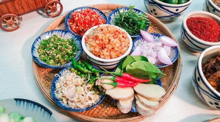 Nguyên liệu chuẩn bị làm chân gà sốt thái bao gồm sả, ớt, quất và các loại rau gia vị