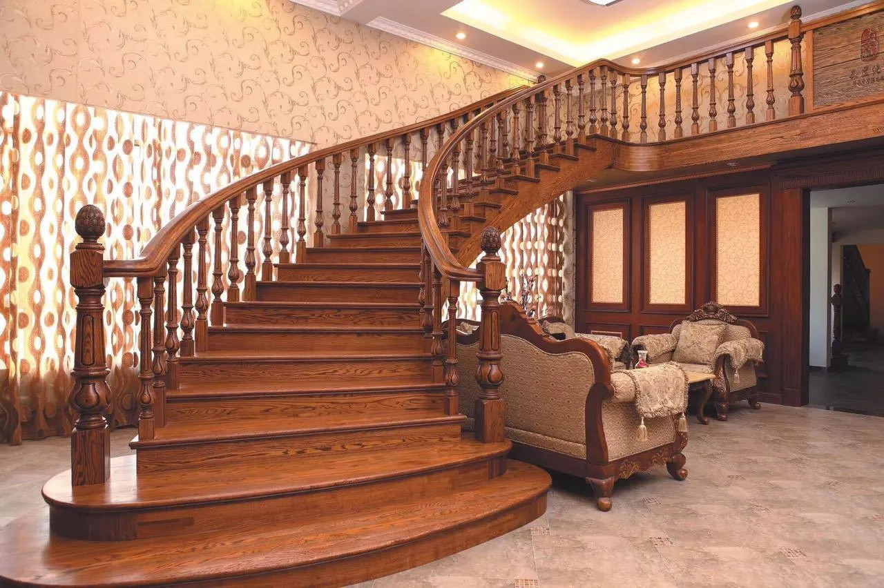 Mẫu cầu thang gỗ cổ điển với lan can chạm khắc hoa văn phức tạp, phù hợp cho biệt thự sang trọng