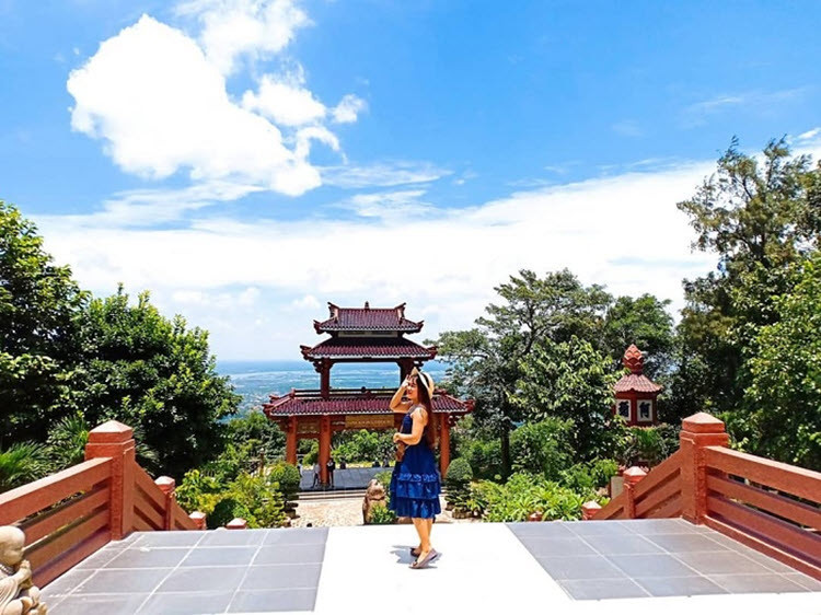 Khuôn viên chùa Linh Sơn Bửu Thiền Tự rợp bóng cây xanh, xa xa là bờ biển trải dài rất đẹp mắt