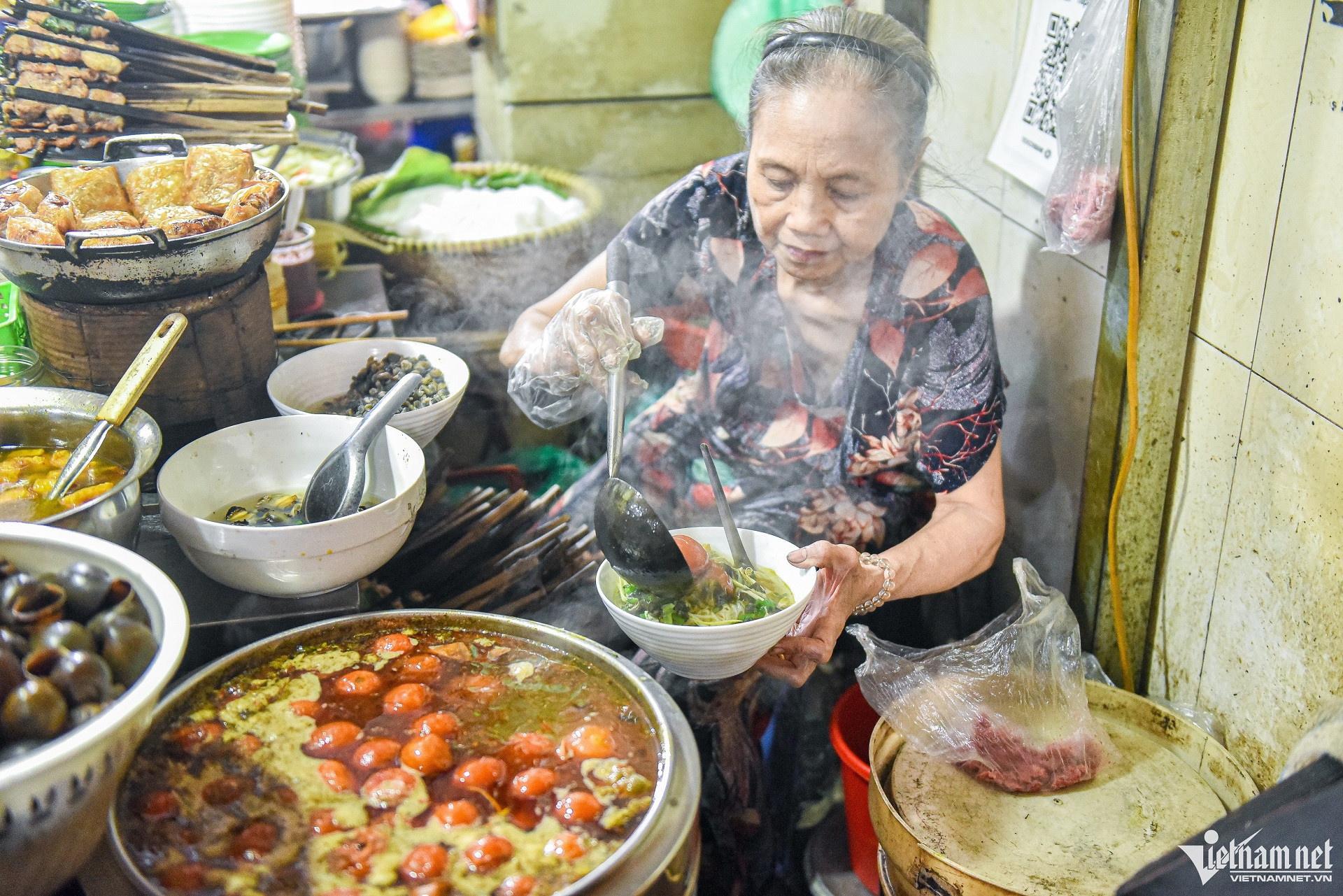 Bát bún ốc Bà Nhung với ốc nhồi béo múp và nước dùng chua thanh, mang đến trải nghiệm ẩm thực đặc sắc tại ngõ chợ Đồng Xuân.