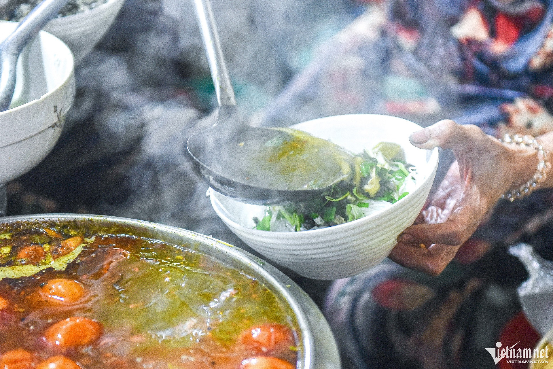 Khung cảnh quán bún ốc Bà Nhung tấp nập khách, với các nguyên liệu tươi ngon được chế biến liên tục, khẳng định vị thế món bún ốc ngon Hà Nội.