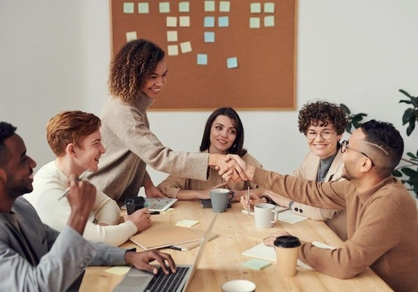 Hai người bắt tay thể hiện sự hợp tác và thành công trong sự nghiệp, minh họa cho ý nghĩa nốt ruồi ở tay phải mang lại may mắn công việc