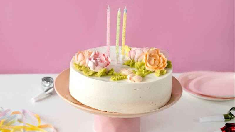 Mẫu bánh kem sinh nhật đẹp cùng hoa tươi tinh tế, làm nổi bật không gian máy tính