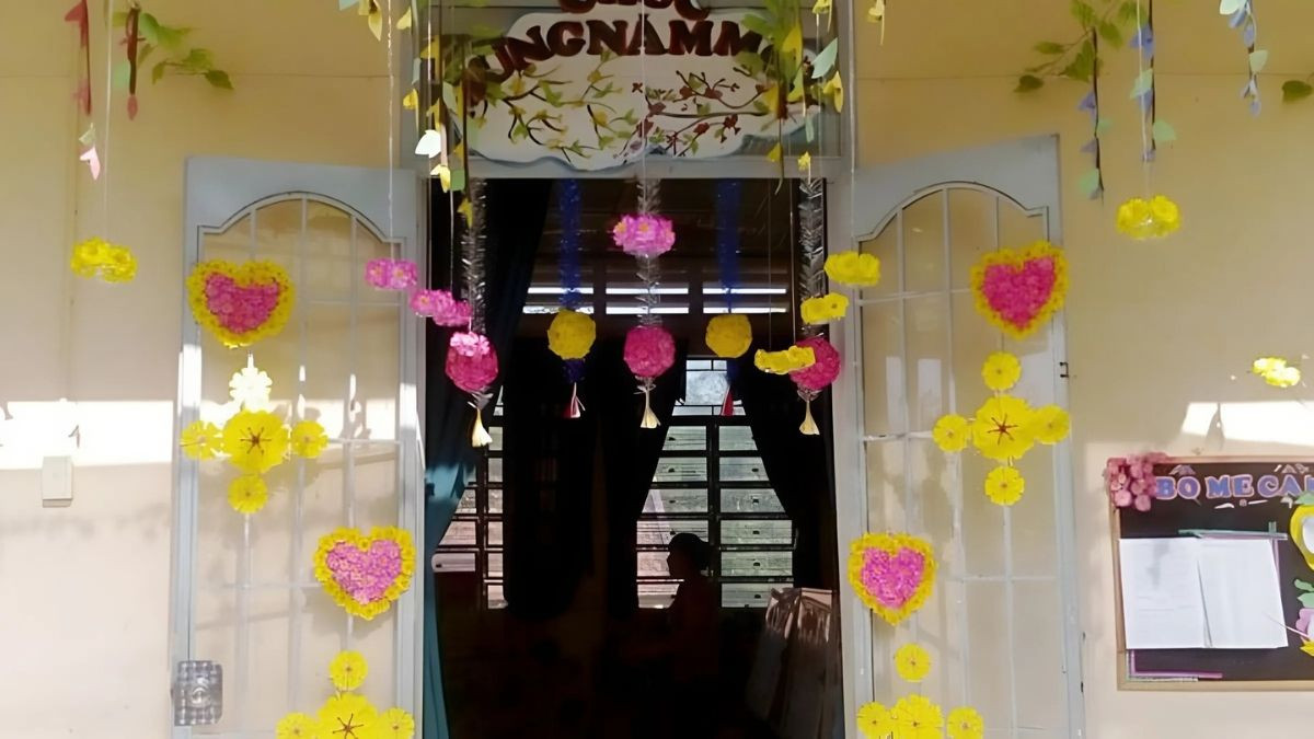 Cửa lớp mầm non trang trí Tết với câu đối và hoa đào