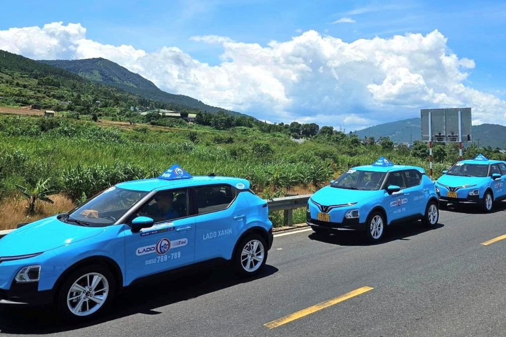 Hình ảnh một chiếc taxi Lado đang di chuyển trên con đường tại Đức Trọng, thể hiện sự hiện diện của hãng trong mọi hành trình