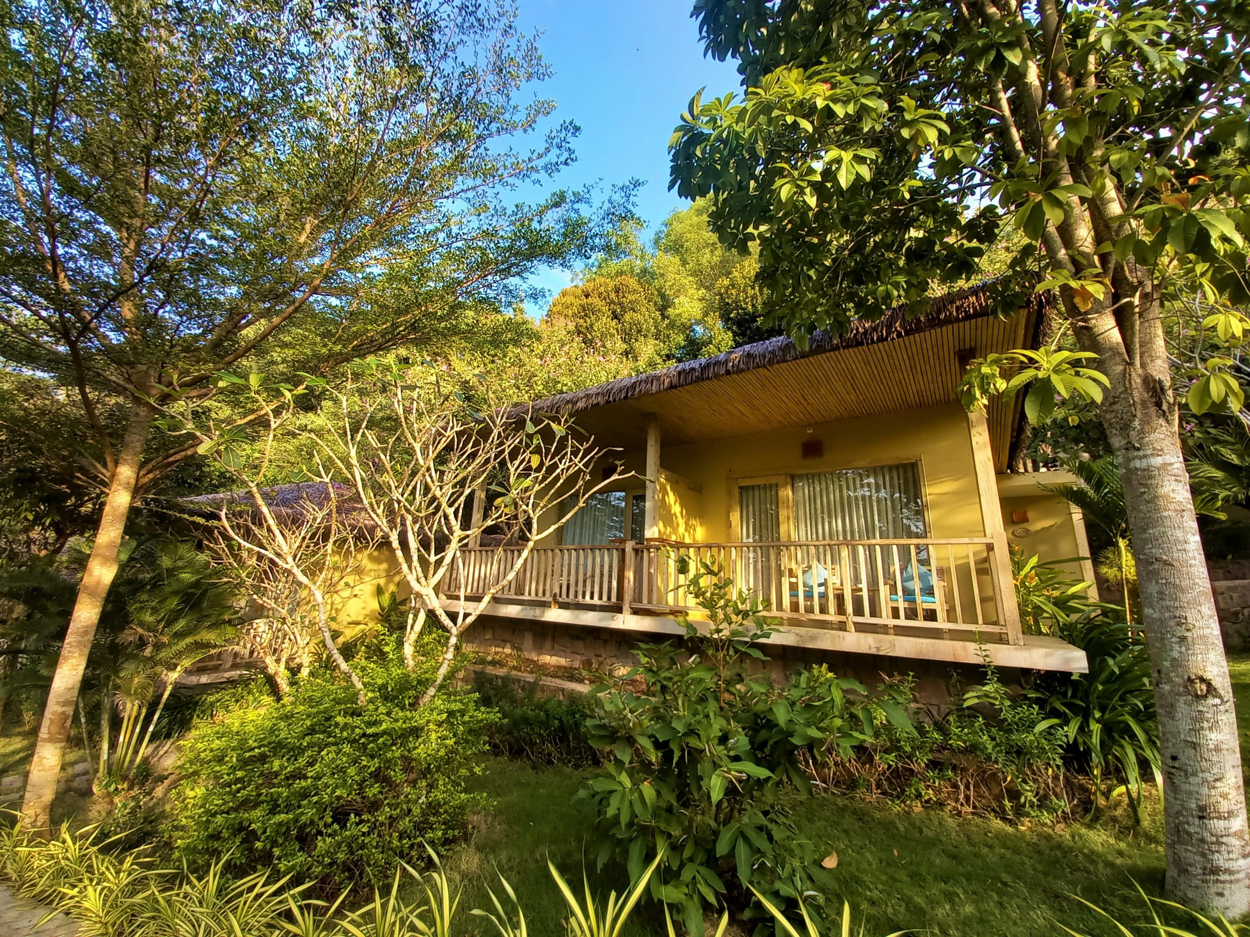 Một góc khu vườn với cây cối xanh tốt và ao cá tại Lahana Resort Phú Quốc