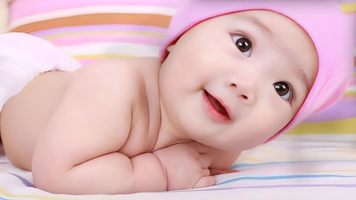 Em bé sơ sinh đáng yêu đang ôm chặt chú thỏ bông