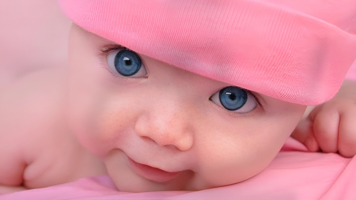Em bé nằm ngửa, cười tươi rói trước ống kính