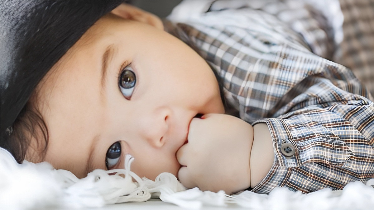 Em bé tóc xoăn với chiếc áo len dễ thương