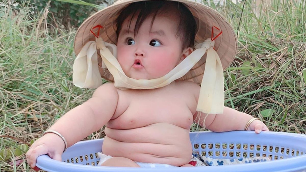 Meme em bé với chiếc khăn choàng lớn, trông rất đáng yêu
