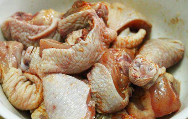 Gà ta chặt miếng lớn đang được ướp với gia vị trước khi chế biến lẩu gà tiềm ớt hiểm