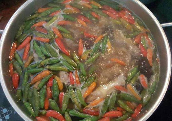 Nước lẩu gà tiềm ớt hiểm đang sôi nhẹ, thơm lừng mùi gà và gia vị đặc trưng
