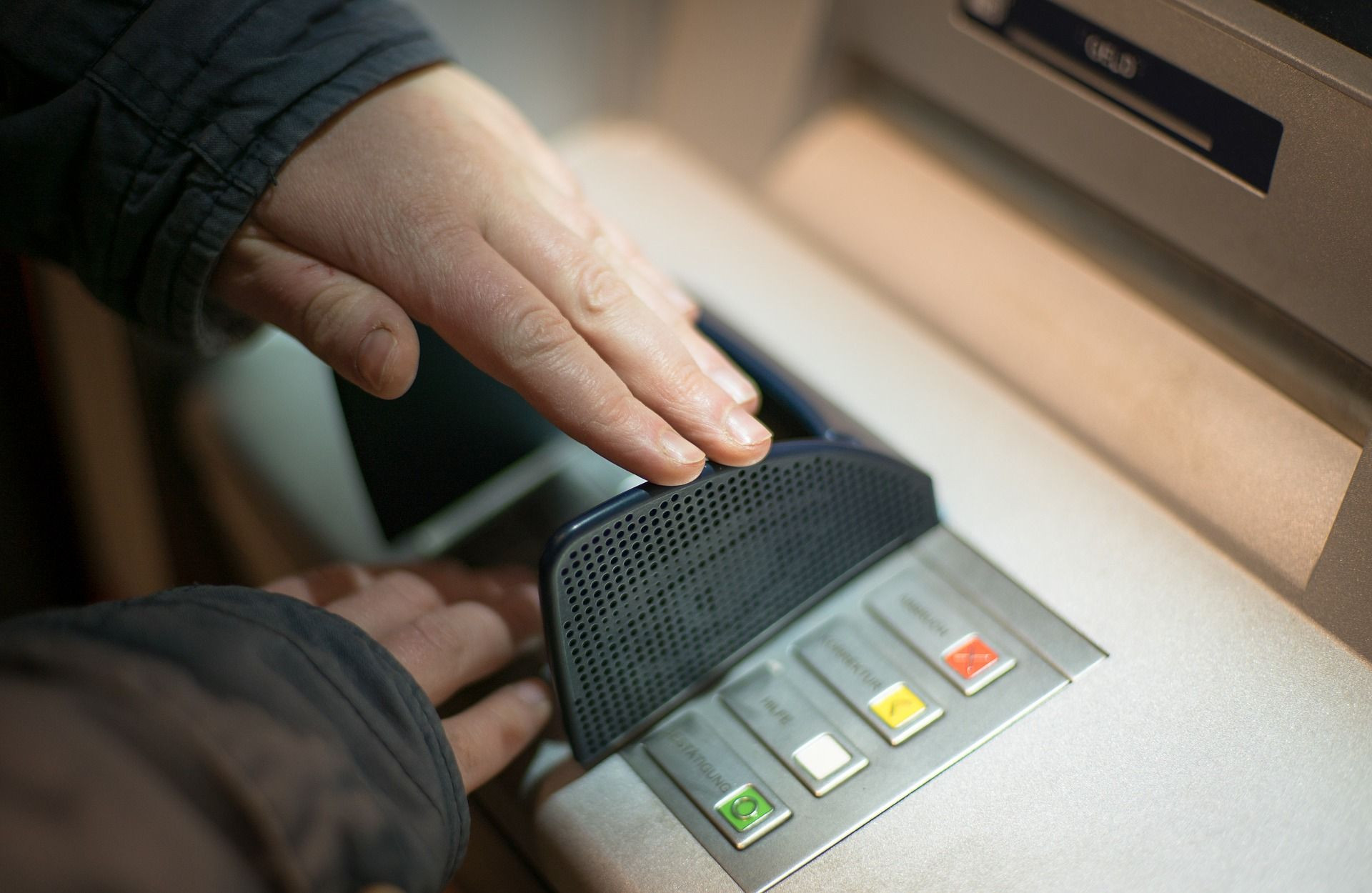 Người dùng nhận tiền mặt và thẻ ATM Agribank từ khe trả tiền của máy ATM