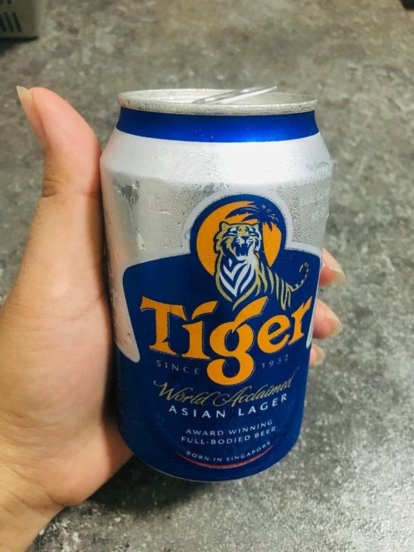 Người đàn ông với lon bia trong không gian mở, hình ảnh nhậu một mình thư giãn giữa thiên nhiên.