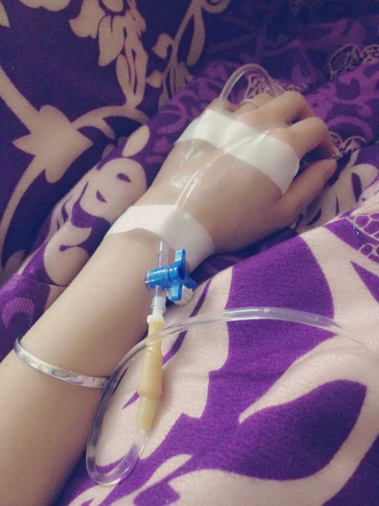 Ảnh một người bệnh đang nằm viện truyền nước, tay được cố định kỹ càng.