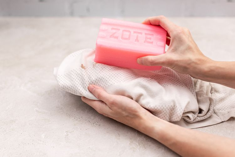 Bánh xà phòng Zote màu hồng được chà lên vết thức ăn trên chăn