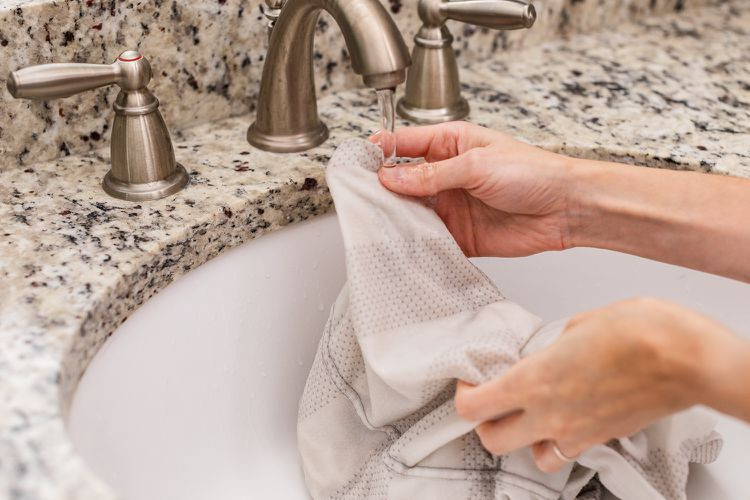 Vải dính bẩn được xả dưới vòi nước chảy