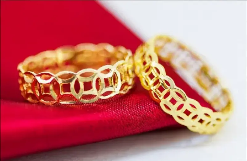 Một người đang đeo chiếc nhẫn kim tiền vàng 24K lấp lánh trên ngón tay, biểu tượng của sự may mắn và thịnh vượng cá nhân