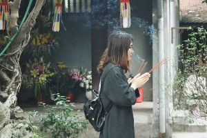 Người học sinh thành tâm cầu nguyện tại chùa để cầu may mắn thi cử
